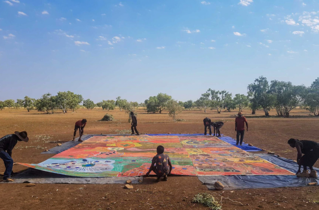 Unrolling the Ngurrara II Canvas. Image courtesy ABC Kimberley.